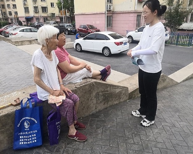 實(shí)踐隊(duì)員在長樂小區(qū)與老人采訪宣傳
