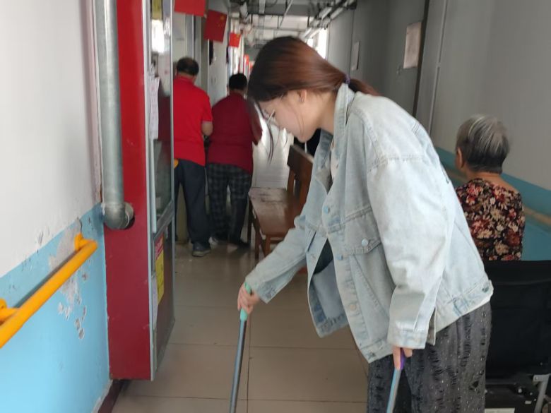 圖為實踐團成員苗欣語在老年公寓打掃衛(wèi)生